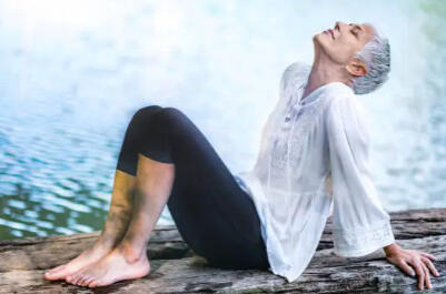 Active senior woman practicing mindfulness by the water